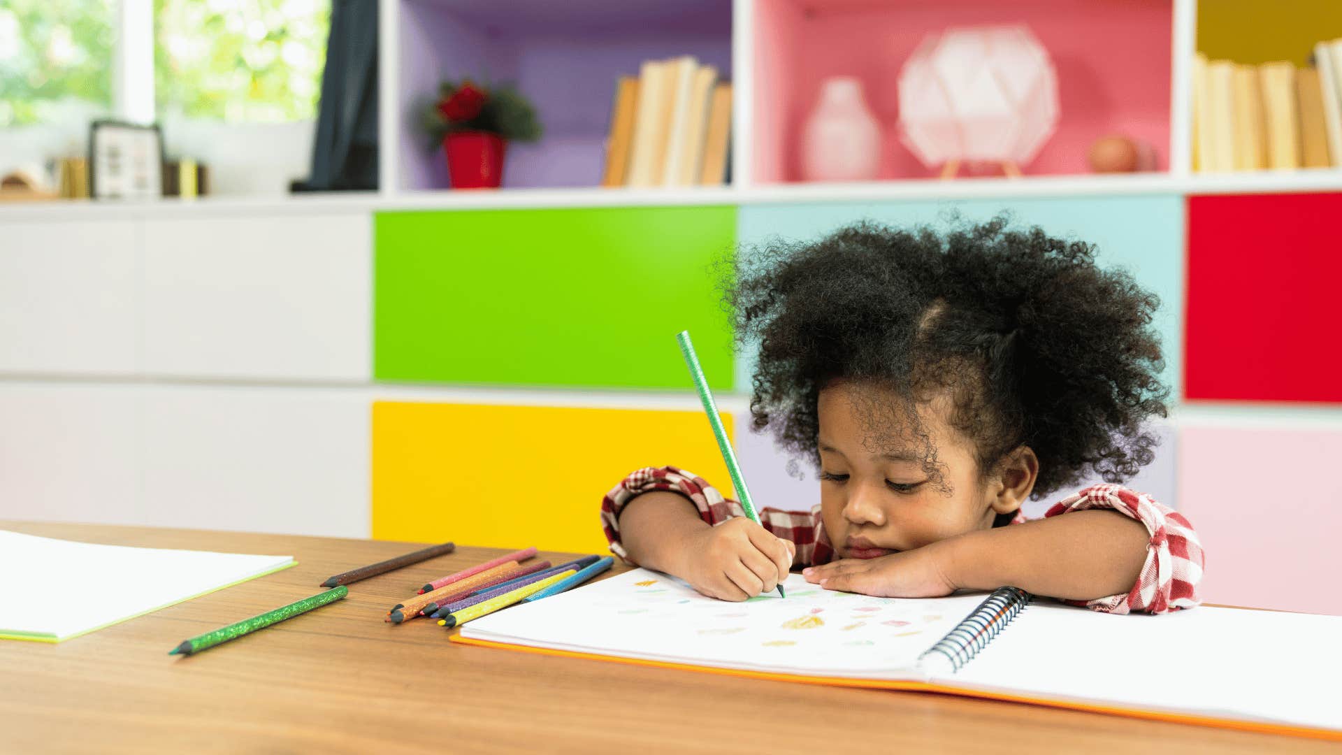 Little girl who was soft parented drawing freely in a colorful room 