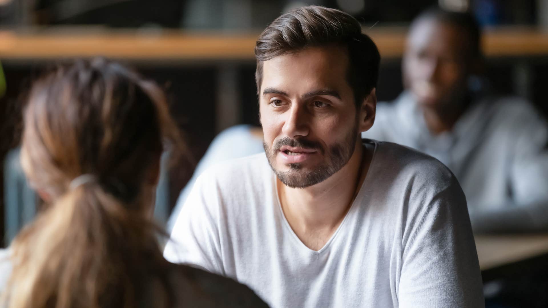 man in white shirt asking woman do i know everyone going or is it possible there are going to be new people there as they sit across from one another at shop