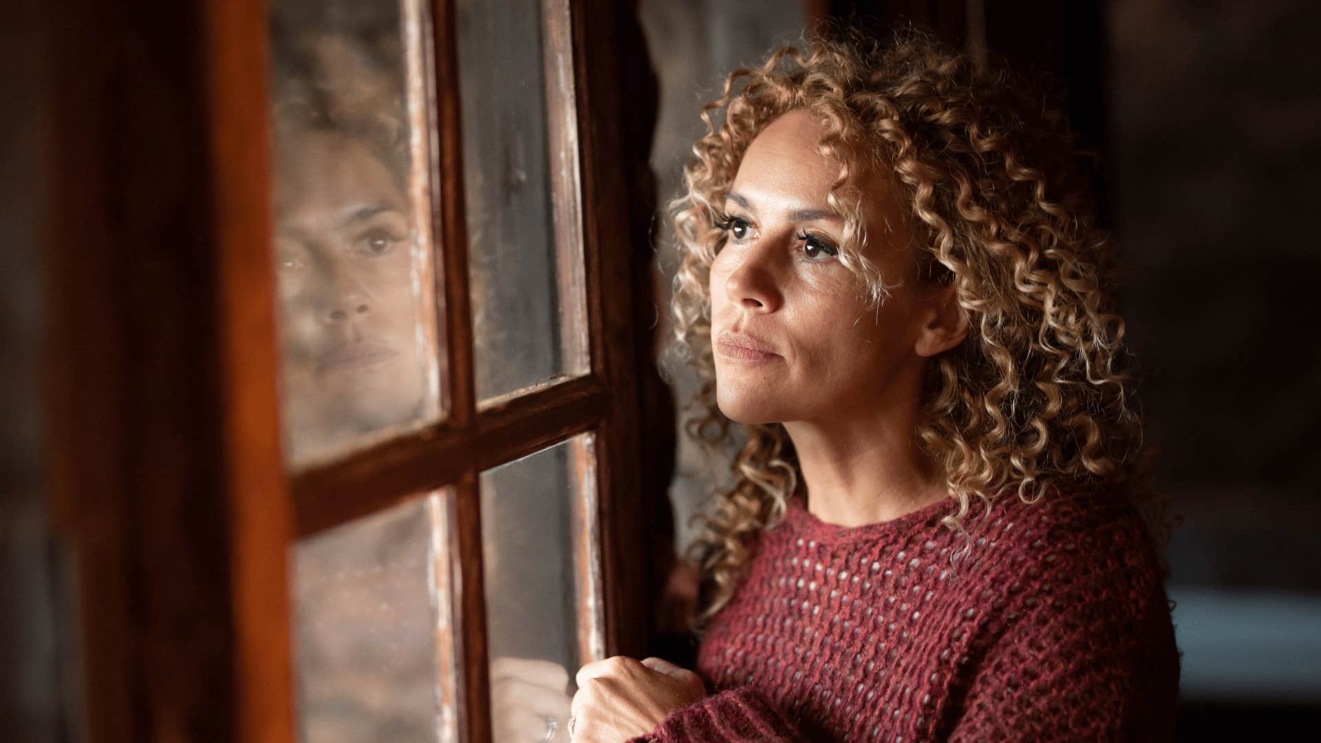 woman looking out the window ignoring her dreams