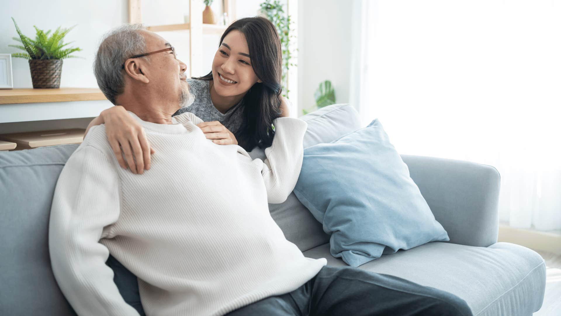 Grandfather with teen granddaughter chatting in the living room