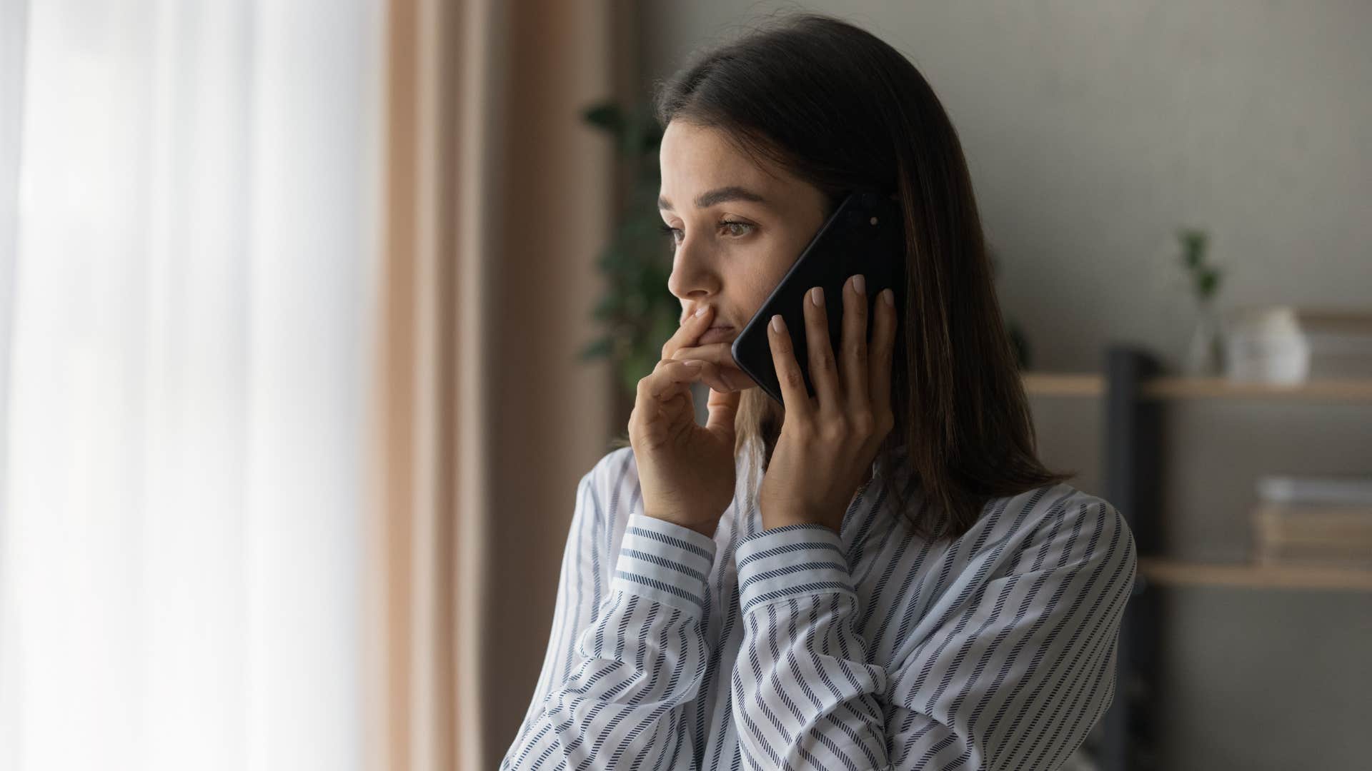 young woman talking on phone with concerned parents