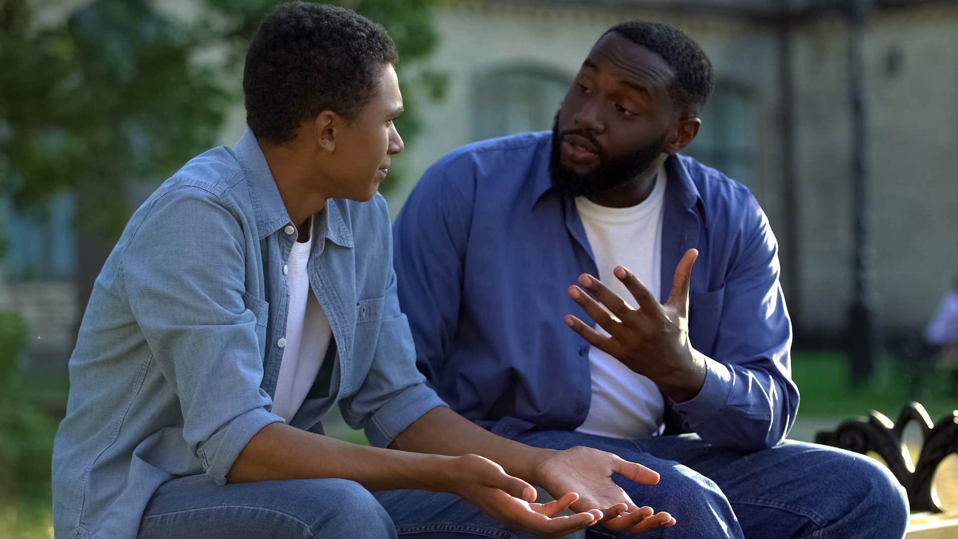 Gen X dad talks to his Gen Z son sternly outdoors
