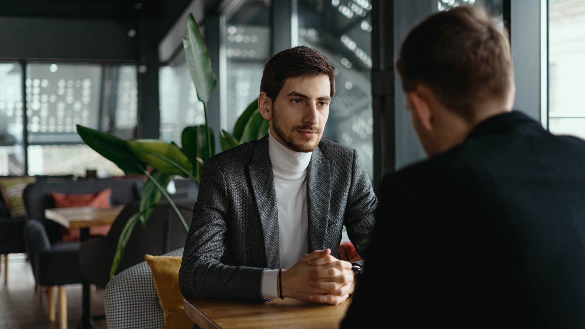 man sitting across from coworker asking on a coffee outing What did that teach you