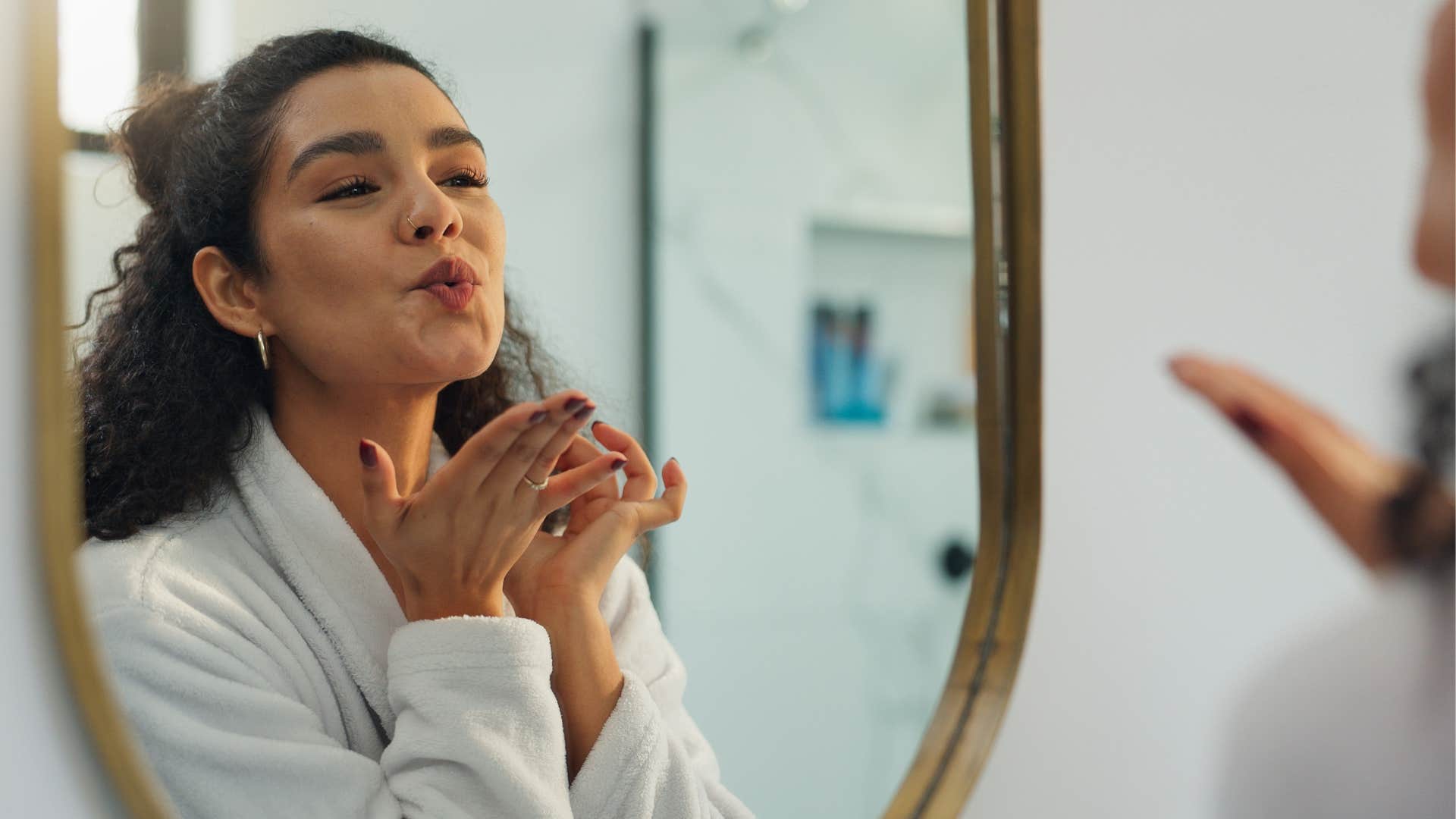 Happy person blows kiss to self in mirror showing habit after divorce