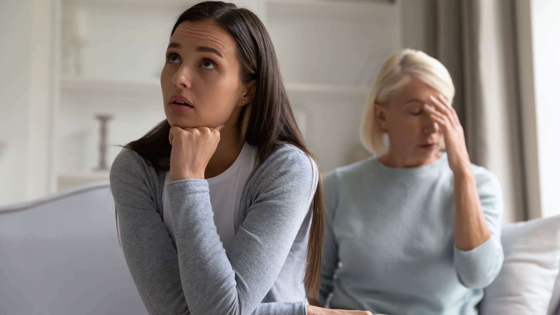 Adult daughter looking upset next to her toxic mother