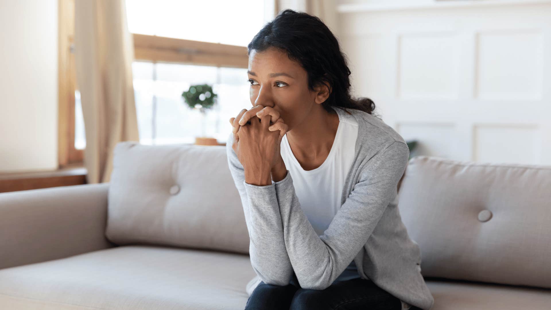 Grown daughter looking sad on the couch 