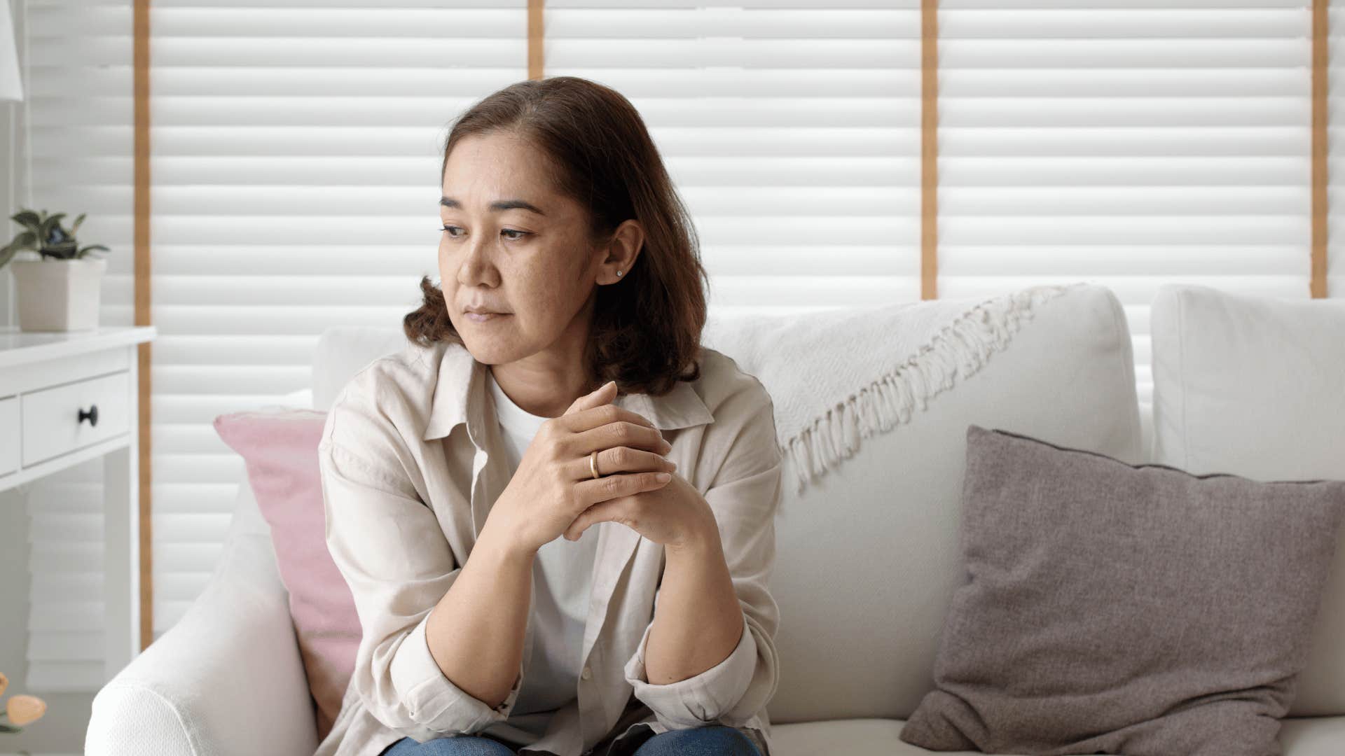 Mom of grown kids sitting alone sadly 