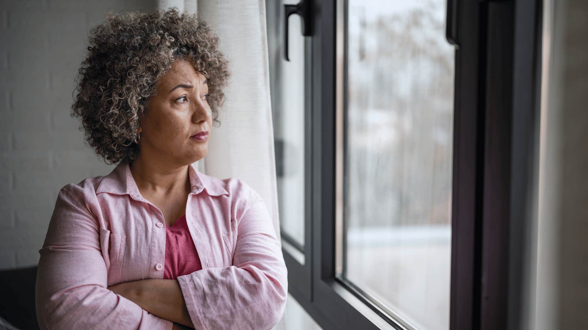 Mother looking out the window waiting for grown-up kids