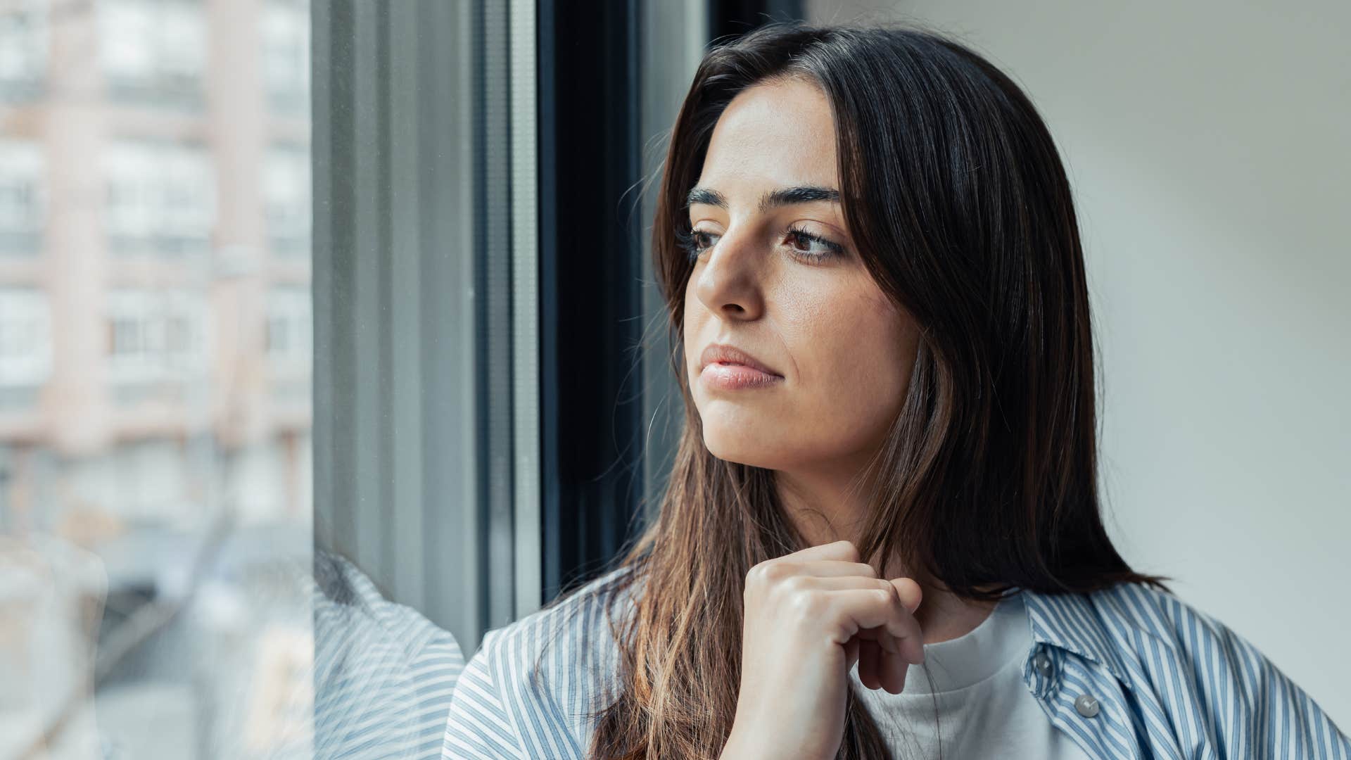 woman looking out the window thinking i'm just in my head right now as she's deep in thought