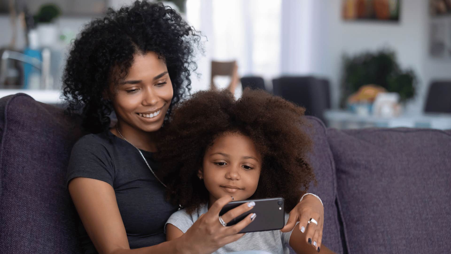 Mom showing her Gen Z child a phone when the child was young