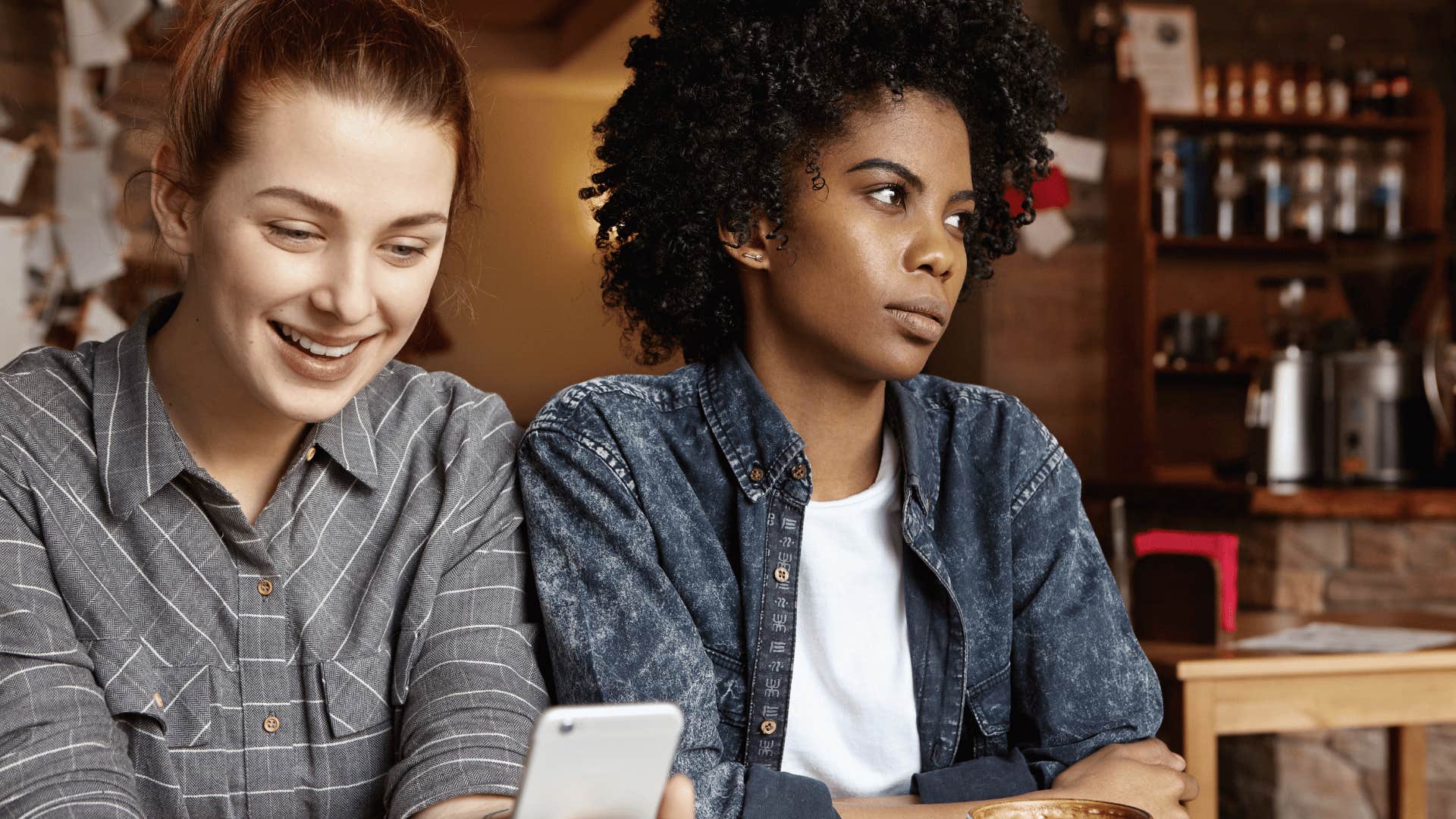annoyed woman sitting next to friend comparing herself