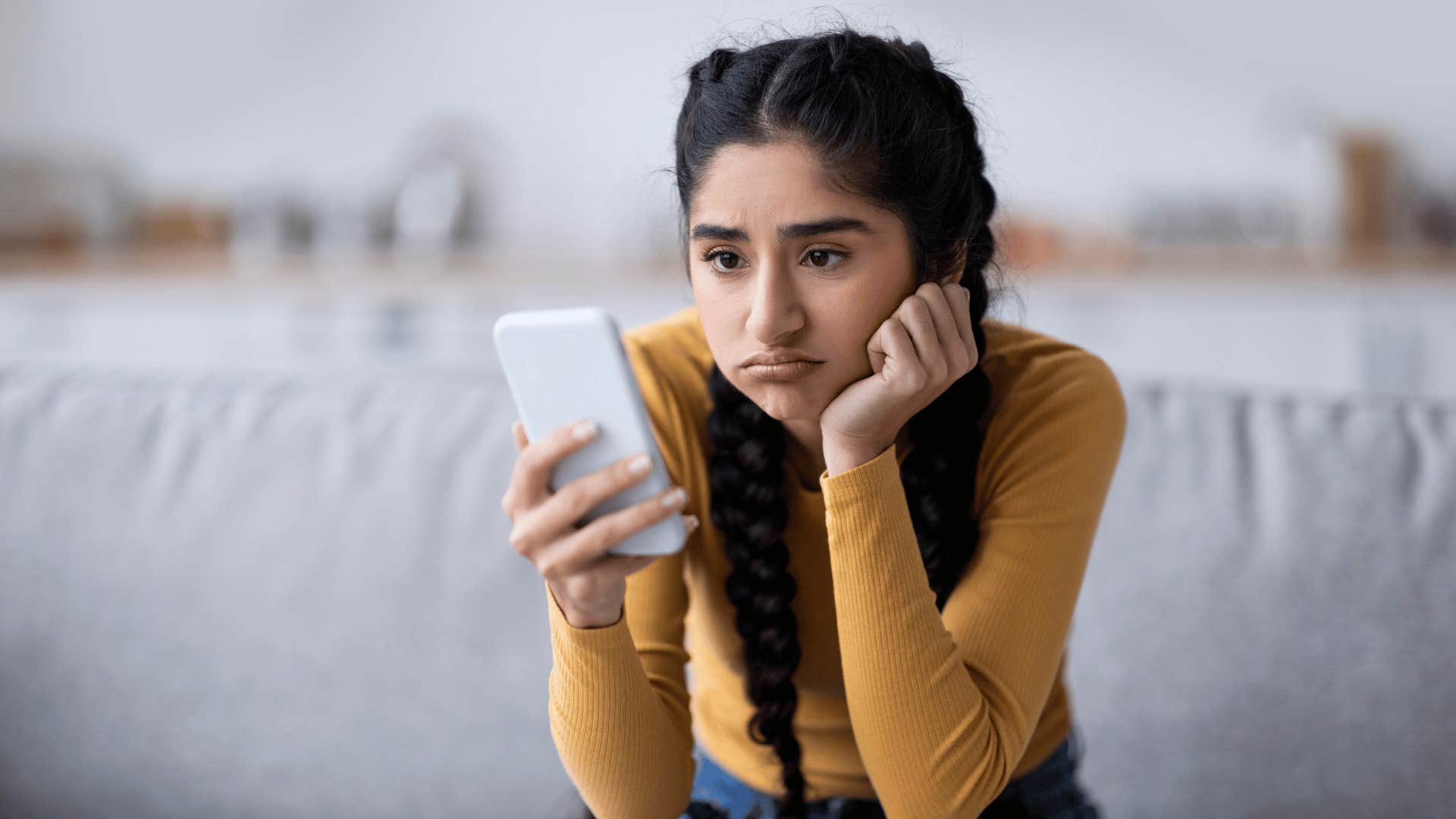 disorganized woman looking at her phone feeling frustrated