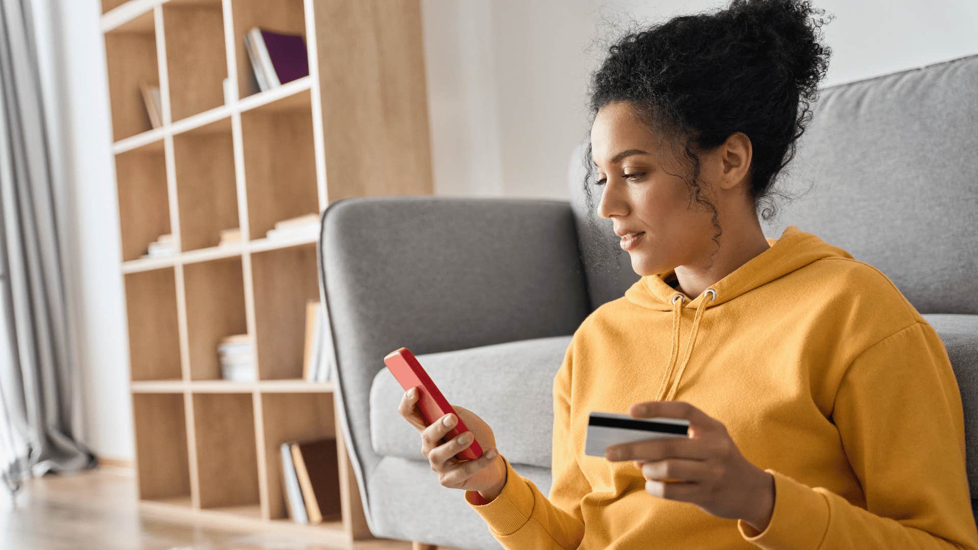 woman using credit card to buy something on her phone